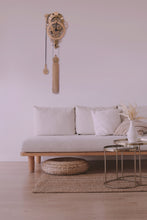 Load image into Gallery viewer, Assembled Vera clock shown mounted in modern white living room. White walls, white couch with wood accents and metallic round coffee table.
