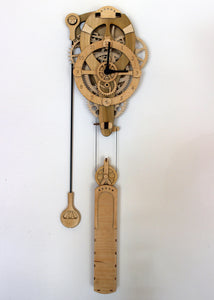 Front full product shot. On a white wall. Gears, head, pendulum and full design shown.