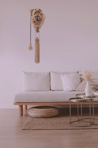 Assembled Vera clock shown mounted in modern white living room. White walls, white couch with wood accents and metallic round coffee table.